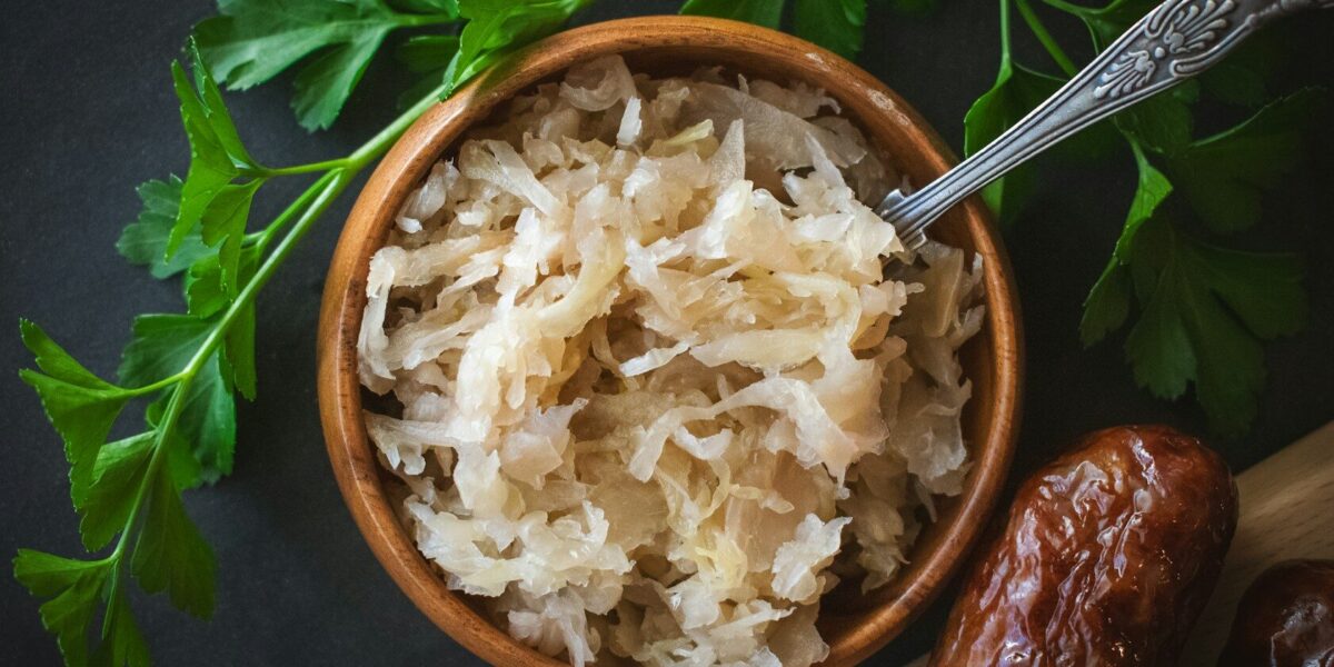 a wooden bowl filled with rice next to a spoon