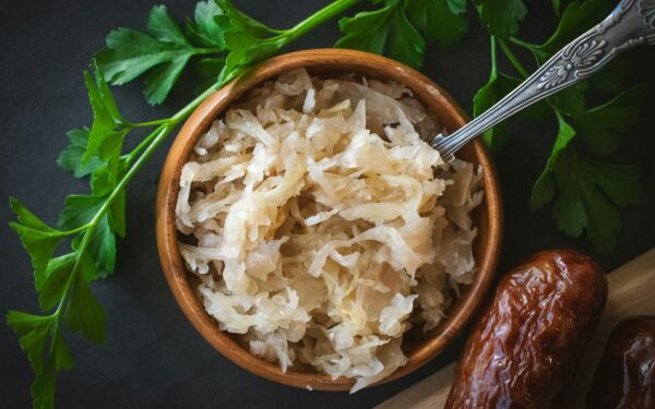 a wooden bowl filled with rice next to a spoon